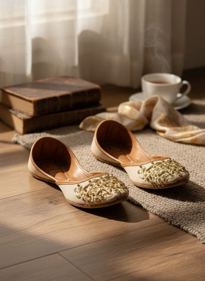 Ujaala beige jutti with intricate gold embroidery and beadwork on the toe. Traditional Indian flat shoe.