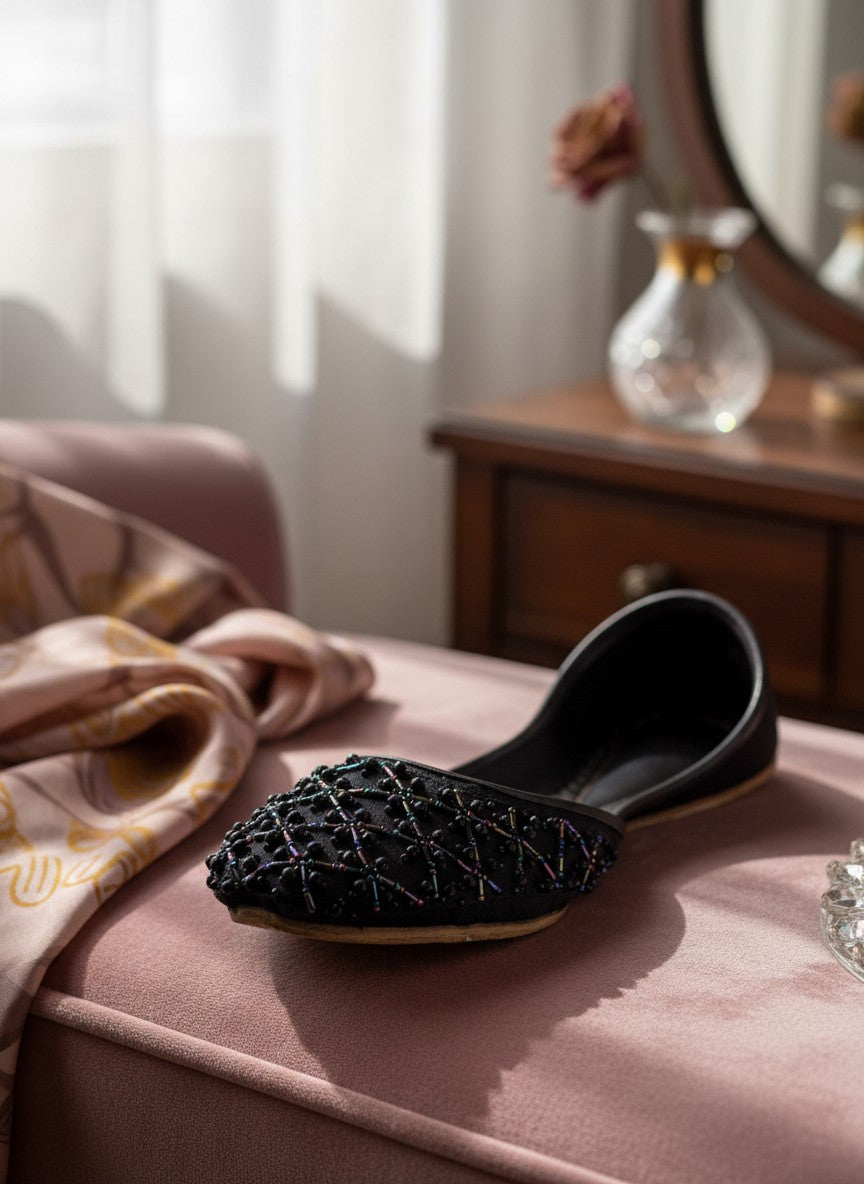 Ujaala Raani black jutti with intricate black beadwork lattice pattern, perfect for festive occasions.