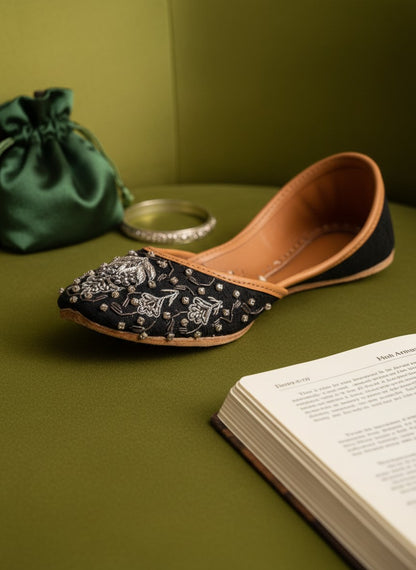 Ujaala Maya black jutti with intricate silver embroidery and beadwork. Flat sole, tan leather lining.