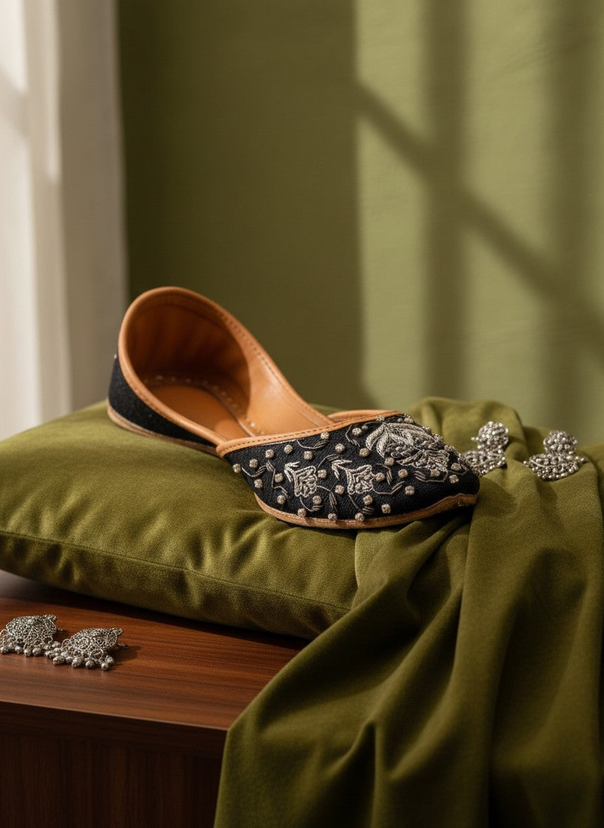 Ujaala Maya black jutti with intricate silver embroidery and beadwork. Flat sole, tan leather lining.