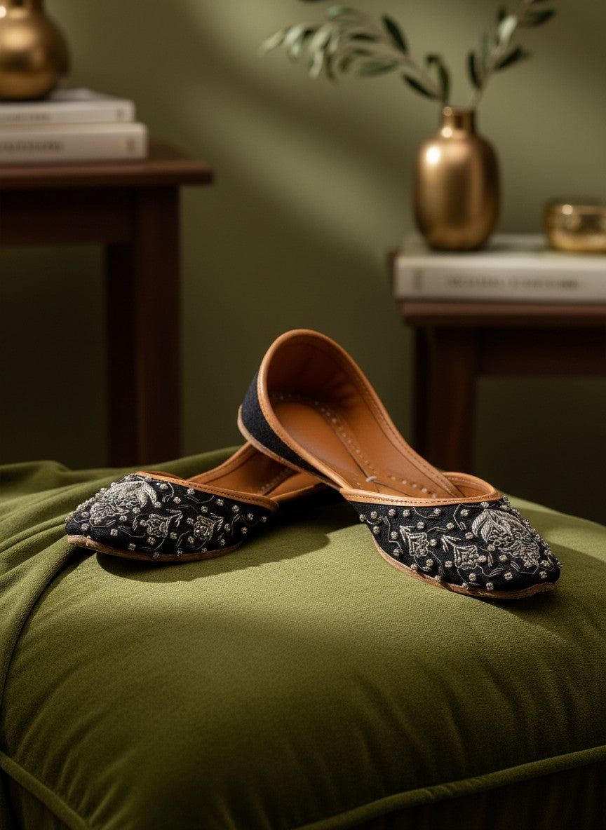 Ujaala Maya black jutti with intricate silver embroidery and beadwork. Flat sole, tan leather lining.