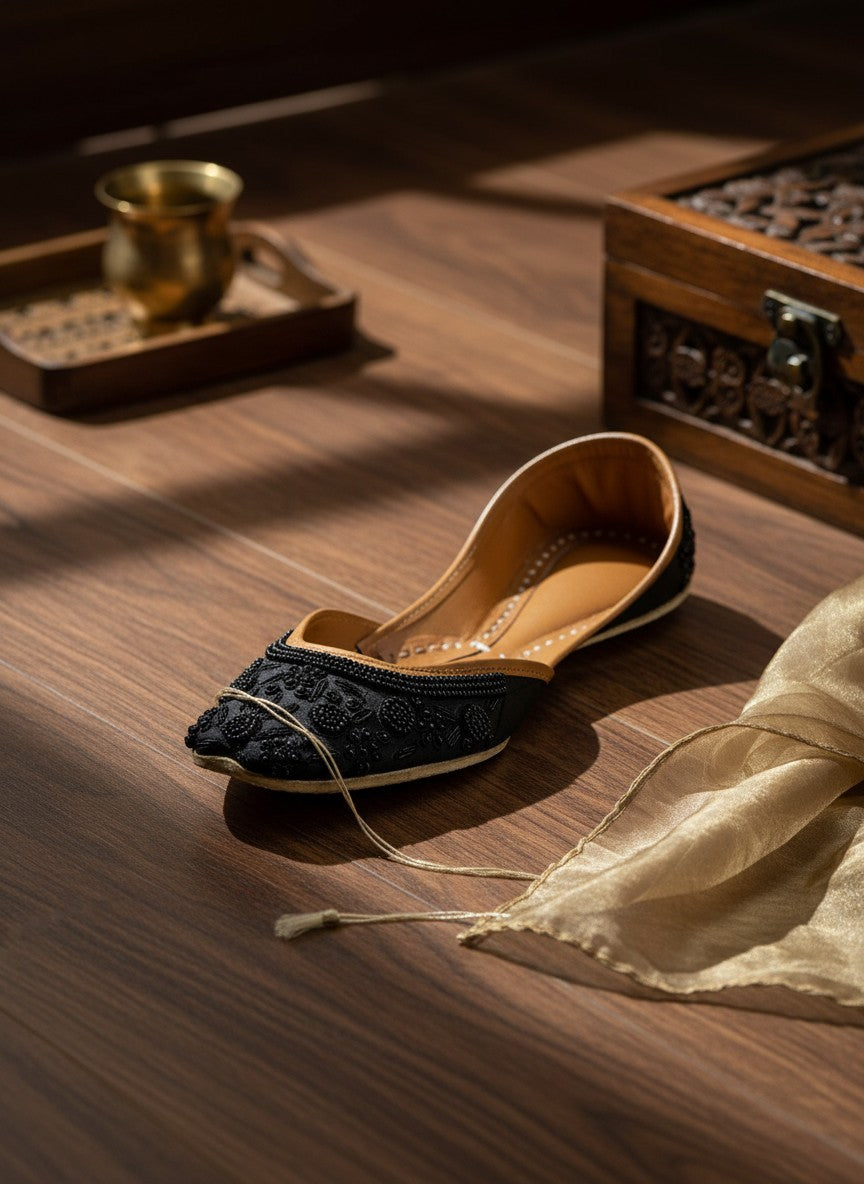 Ujaala Mausam black jutti with intricate floral bead embroidery and tan leather lining.