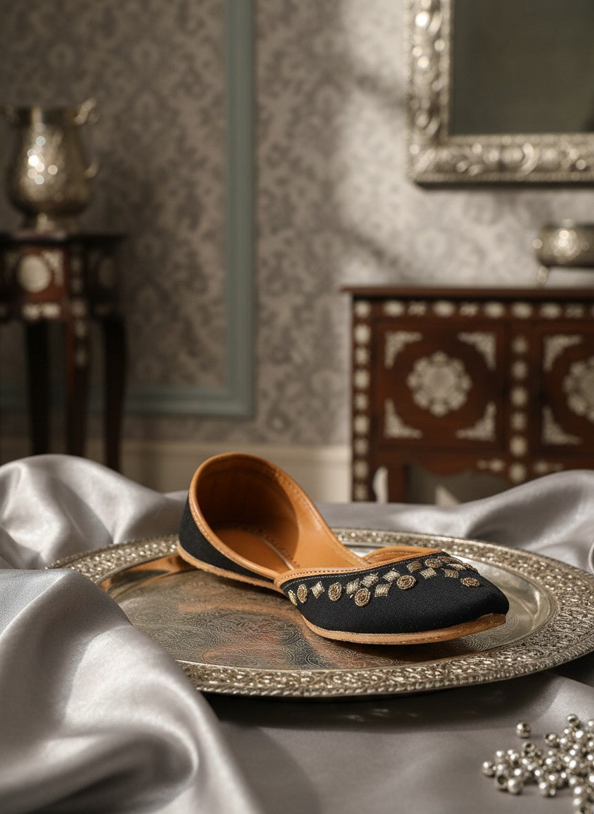 Ujaala black jutti with gold floral embroidery and tan leather lining. Handcrafted flat shoe.