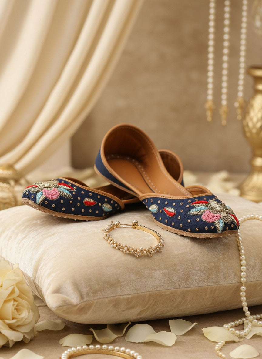 Ujaala Resham blue denim jutti with intricate floral embroidery and gold bead accents.