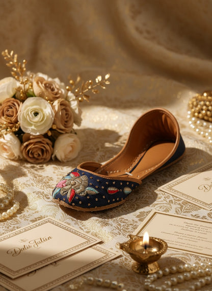 Ujaala Resham blue denim jutti with floral embroidery and gold bead accents.