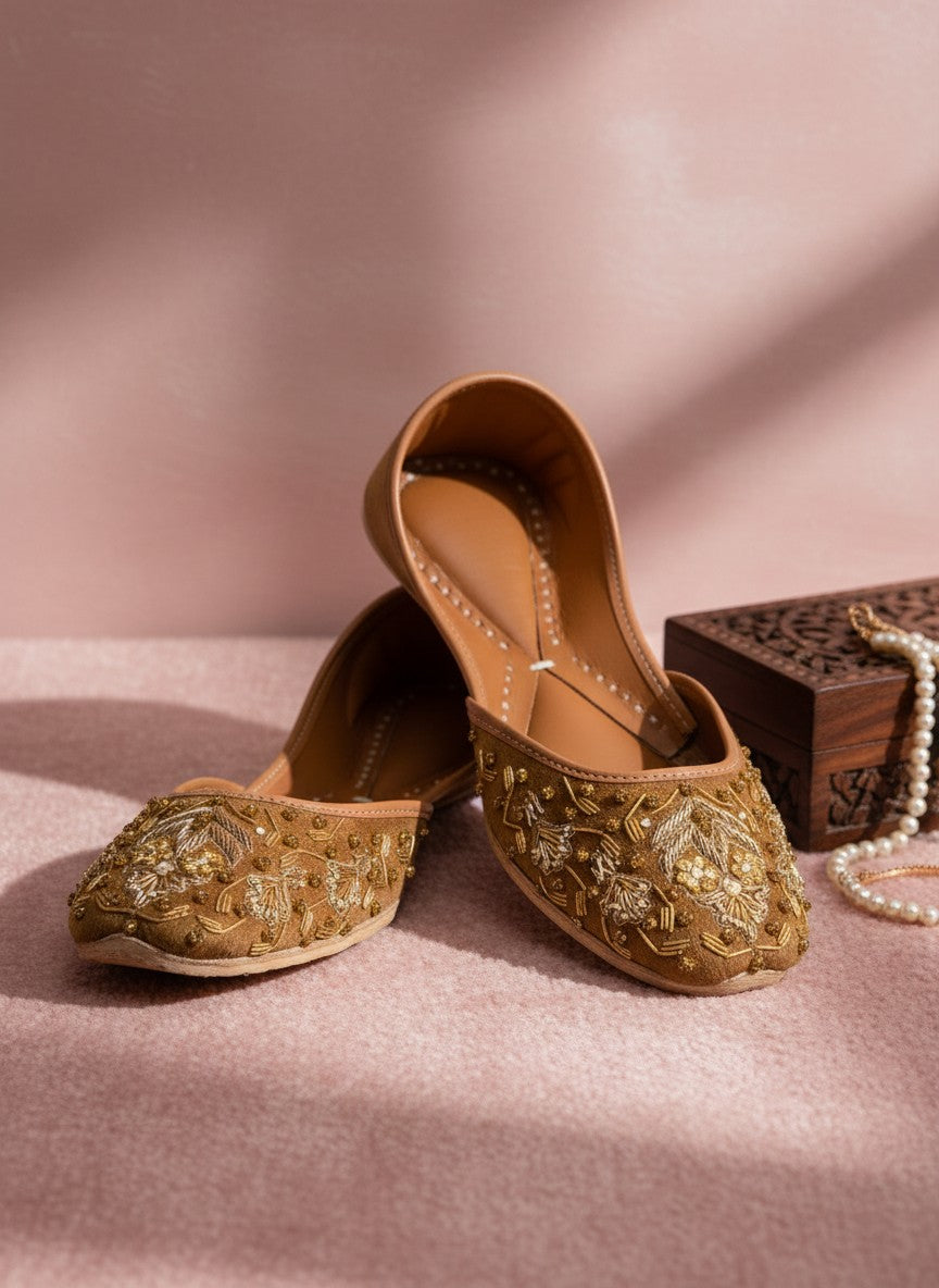 Ujaala brown suede jutti with intricate gold thread and bead embroidery. Flat sole, slip-on style.