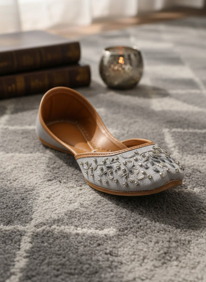 Ujaala Riwa gray jutti with intricate silver floral embroidery and bead embellishments.