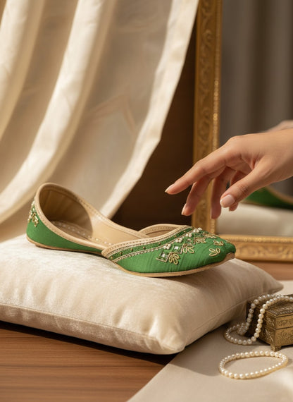 Ujaala green silk jutti with intricate golden embroidery and pearl embellishments, featuring a traditional pointed toe.