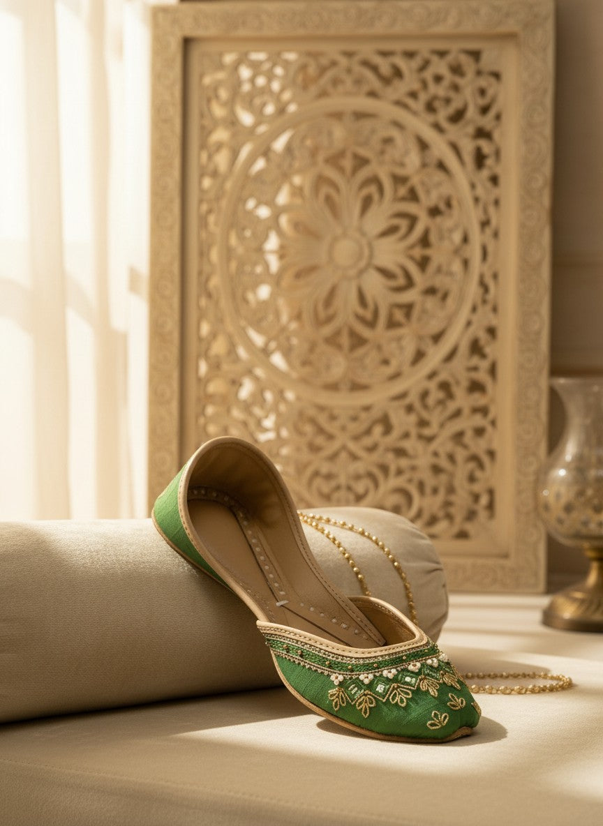 Ujaala green silk jutti with intricate golden embroidery and pearl embellishments.
