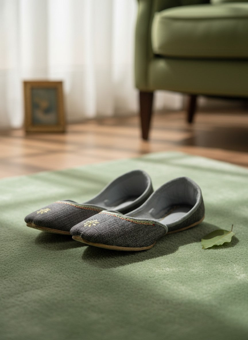Ujaala grey jutti with embroidered flower detail and decorative trim. Handcrafted for comfort.
