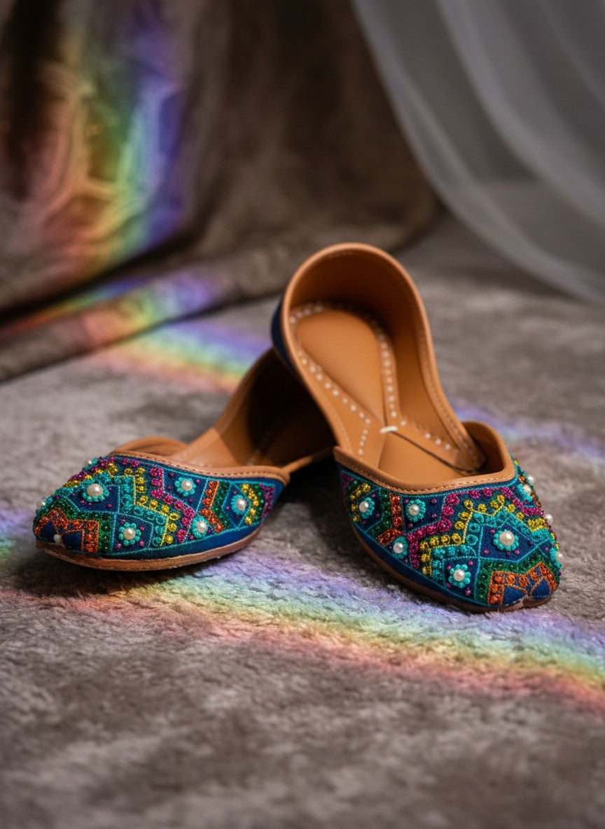 Ujaala multi-color embroidered jutti with pearl accents on a blue suede base.