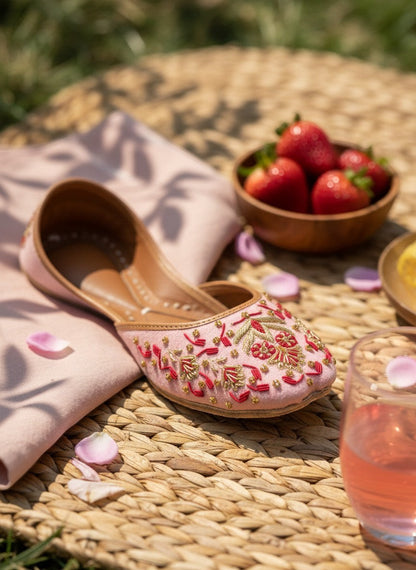 Ujaala blush pink jutti with intricate gold and red floral embroidery. Traditional Indian flat shoe for women, perfect for festive occasions.