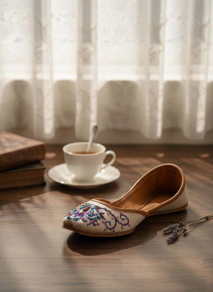 Ujaala Zari white jutti with intricate floral embroidery in blue, purple, and pink beads.