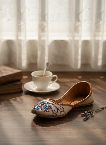 Ujaala Zari white jutti with intricate floral embroidery in blue, purple, and pink beads.