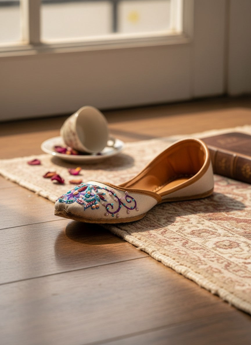 Ujaala Zari white jutti with intricate floral embroidery in blue, purple, and pink beads.