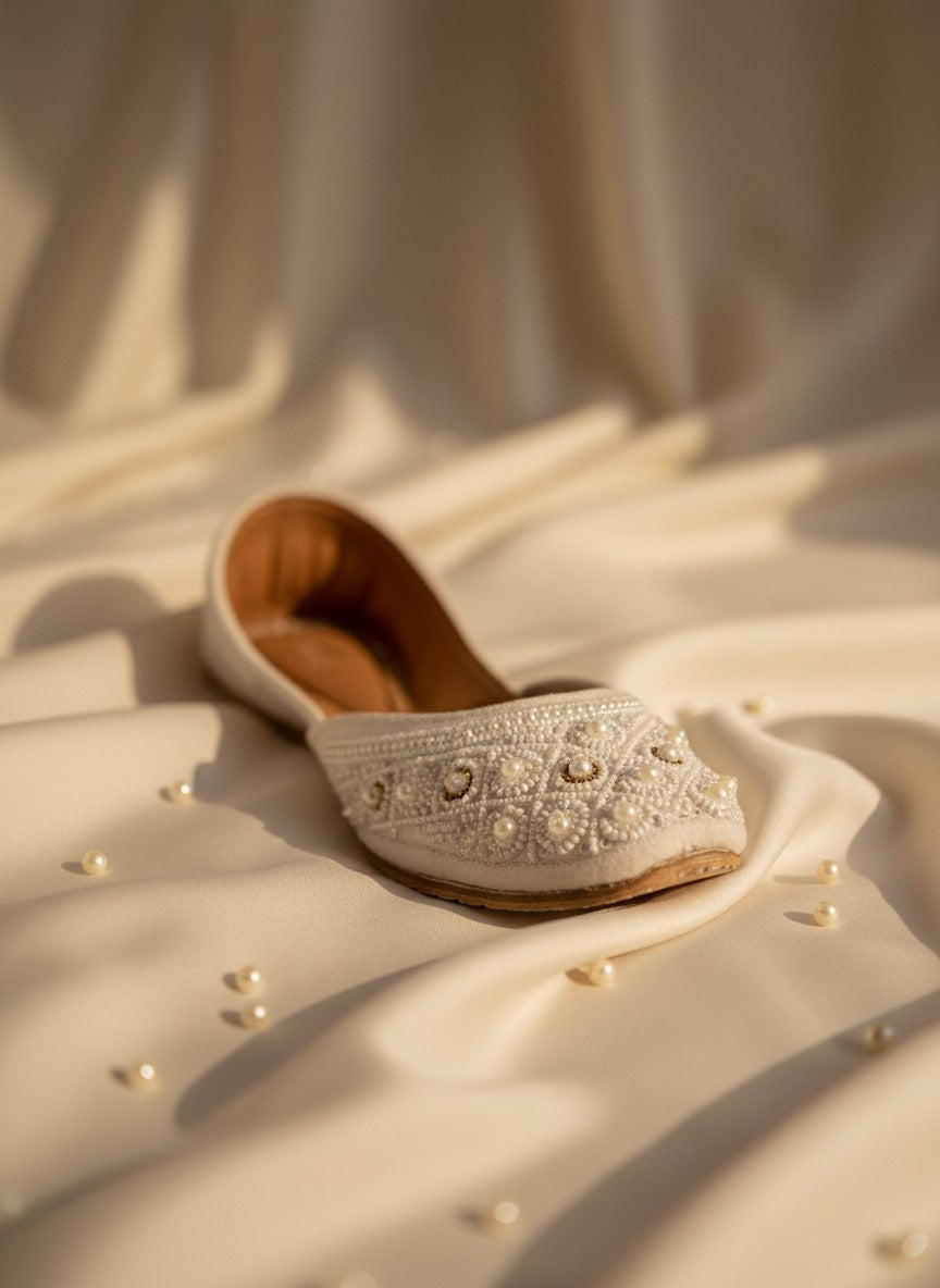 Ujaala Nayaab white jutti embellished with pearls and intricate beadwork, perfect for traditional outfits.