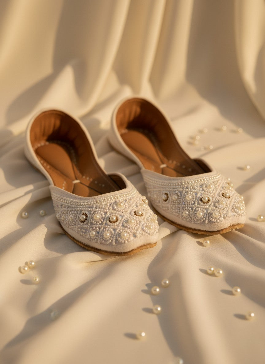 Ujaala Nayaab white jutti embellished with pearls and intricate beadwork. Traditional flat shoe for women.