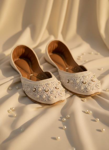 Ujaala Nayaab white jutti embellished with pearls and intricate beadwork. Traditional flat shoe for women.