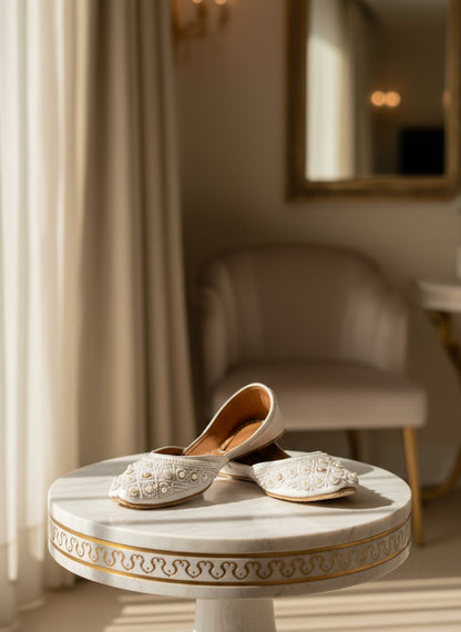 Ujaala Nayaab white jutti embellished with pearls and intricate beadwork. Traditional flat shoes for women.