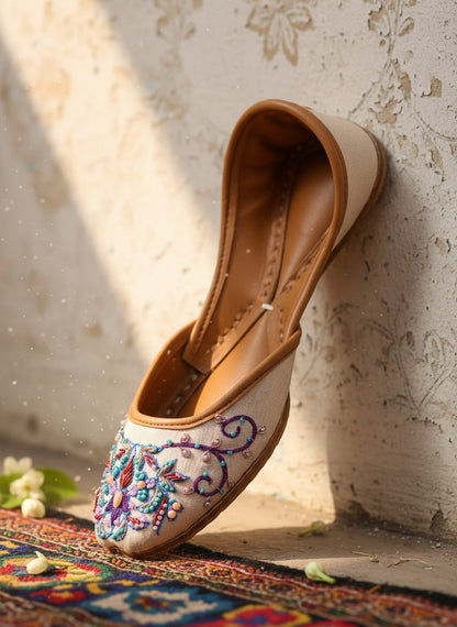 Ujaala Zari white jutti with intricate floral embroidery in blue, purple, and pink beads.